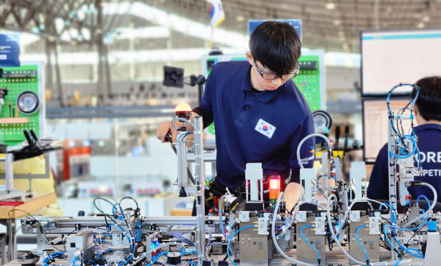 국제기능올림픽에 출전한 대한민국 국가대표 선수가 작업에 몰두하며 대회에 참가하고 있습니다.