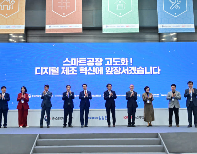 스마트비즈엑스포 행사에 중소벤처기업부, 삼성, 중소기업중앙회 등 관계자들이 단상에 서서 박수를 치고 있습니다.