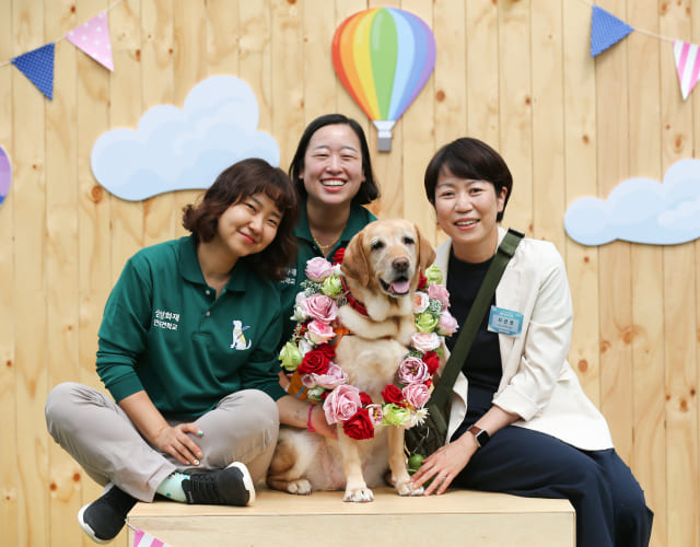 은퇴한 노령 안내견을 입양한 봉사자와 은퇴 안내견, 훈련사가 은퇴 기념 촬영을 하고 있습니다.