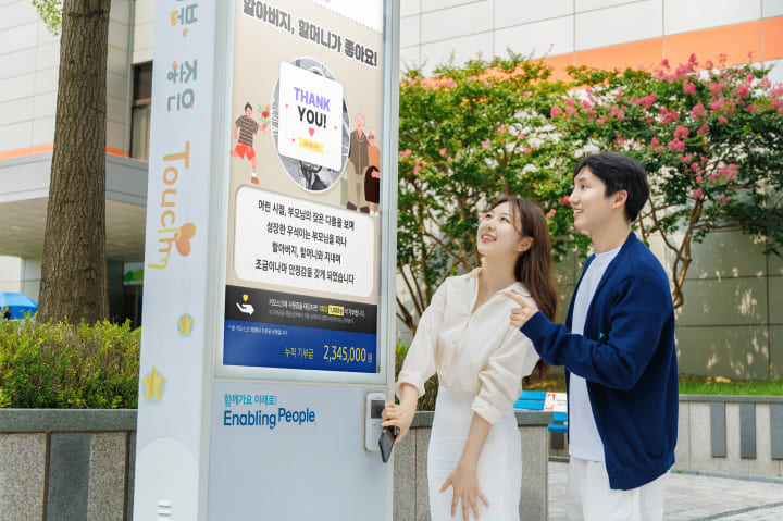 삼성 직원들이 나눔키오스크에 태깅하며 기부하고 있습니다.